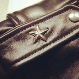 a close up of a leather strap with a star metal on it