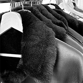 leather jackets with faux fur collars hung on a rack 