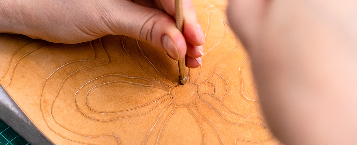 a person hand branding a pattern into leather